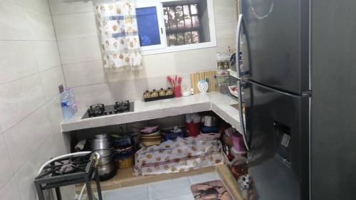 a kitchen with a refrigerator and a shelf with food at Constantine in Constantine