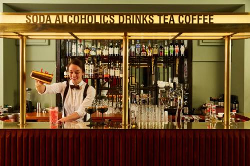 a woman standing behind a bar with a bottle of wine at Hotel Indigo Atlanta Midtown by IHG in Atlanta