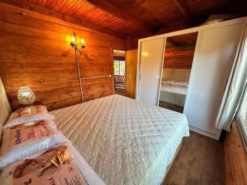 a bedroom with a bed in a wooden cabin at Macondo in Sauce de Portezuelo