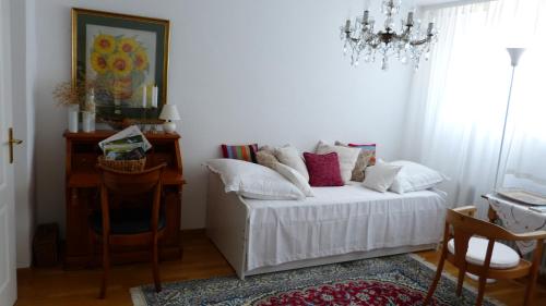 a living room with a white couch and a chandelier at Eifelidylle am MoselMaareRadweg in Wittlich