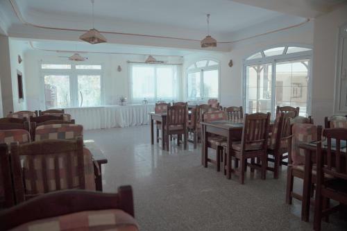 ダハブにあるDahab Hotelのテーブルと椅子と窓のあるダイニングルーム