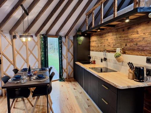 a kitchen with a table in a tiny house at Jurta Leśne Zacisze StOdOlNiA 