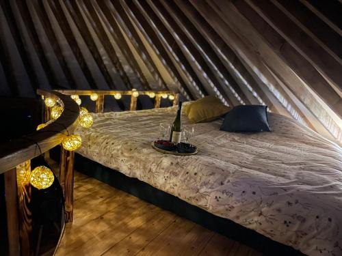 a bed in a yurt with a bottle of wine on it at Jurta Leśne Zacisze StOdOlNiA 