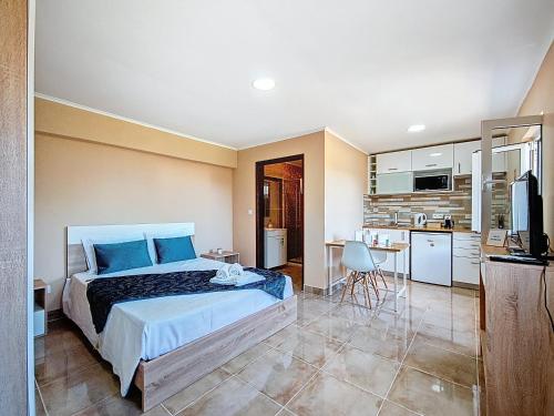 a bedroom with a large bed and a kitchen at Cantinho da Lourdes e Tonito Nº 136193/AL in Miro