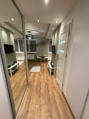a room with a hallway with a table and a mirror at Chill Apartament Gdynia in Gdynia