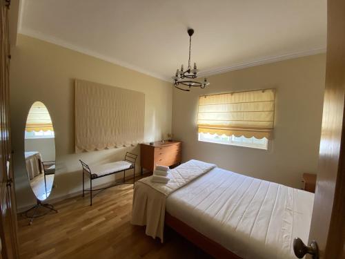 a bedroom with a bed and a chair and a window at B House Verdizela in Corroios