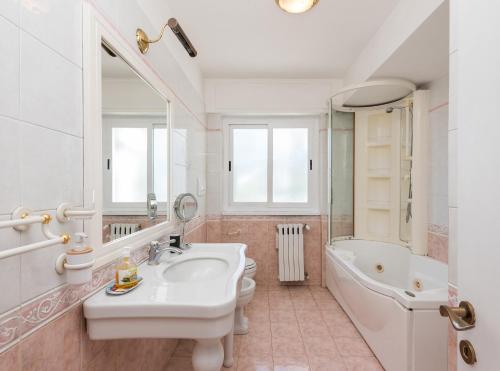Un baño con lavabo, bañera e inodoro. en Vatican-Metro A Panoramic Penthouse with Jacuzzi, en Roma