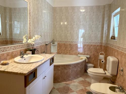 a bathroom with a tub and a toilet and a sink at B House Verdizela in Corroios