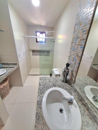 a bathroom with a sink and a shower at Villas do Pratagy Acerola in Maceió