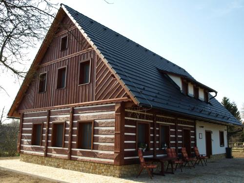 a large wooden house with a gambrel roof at Pension Konírna in Huntířov