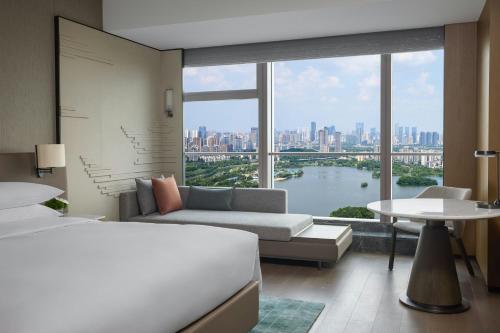 a hotel room with a bed and a large window at Changsha Marriott Hotel West in Changsha