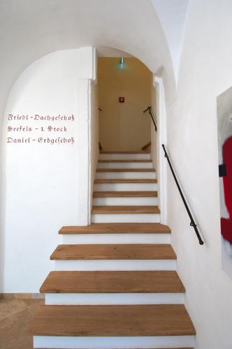 a staircase in a building with white walls and wooden floors at Hotel Landhaus Moserhof in Gumpoldskirchen