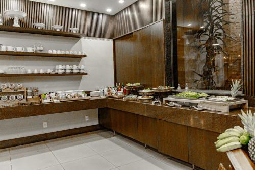a buffet line in a restaurant with food at Café Palace Hotel in Três Pontas