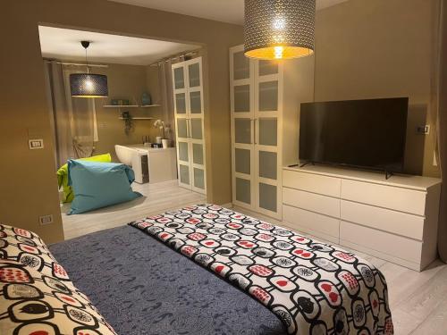 ein Wohnzimmer mit einem TV, einem Bett und einem TV in der Unterkunft B&B Il Gelso - San Pietro in Casale in San Pietro in Casale