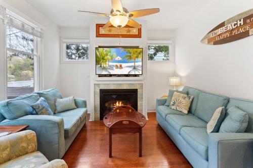a living room with two blue couches and a fireplace at BB47 - A Wave From It All in Croatan Shores