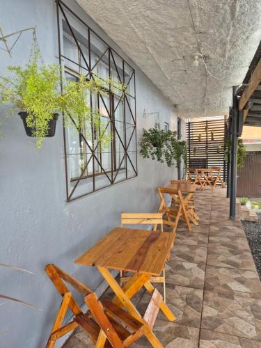 un gruppo di tavoli e panche di legno contro un muro di Hotel El-Shaday a Vila Nova do Sul