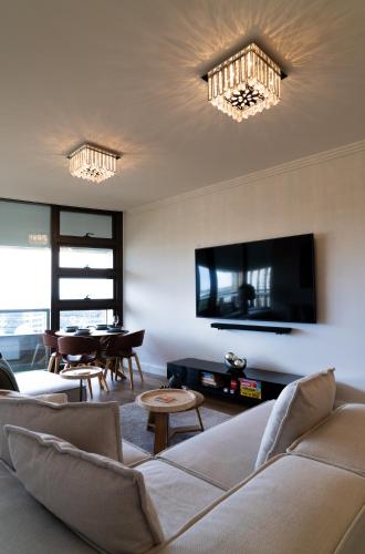 a living room with a couch and a tv at Stadium Retreat in Sydney