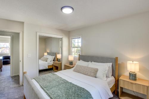 a bedroom with a large white bed and two windows at 19 Mi to Kansas City Group Retreat with Game Room! in Blue Springs