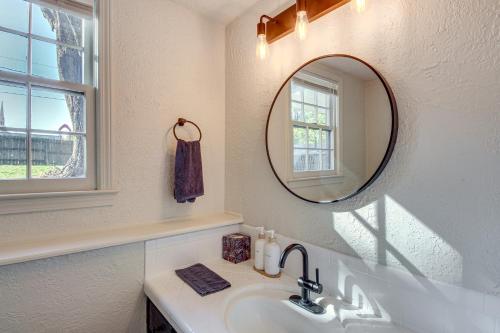 a white bathroom with a sink and a mirror at 19 Mi to Kansas City Group Retreat with Game Room! in Blue Springs