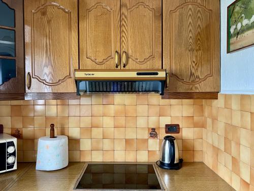 een keuken met houten kasten en een aanrechtblad bij Castle Steps in Gjirokastër