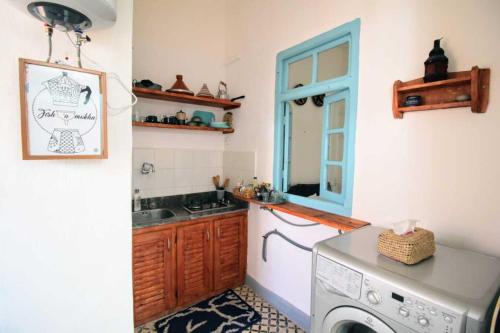 een keuken met een wasmachine en een wastafel bij Dar janna in Essaouira