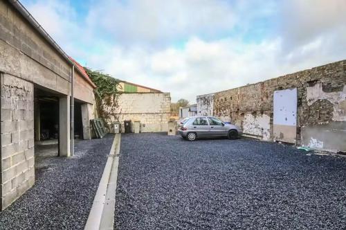 a car parked in a parking lot between two buildings at Le Grenier Chic - T3 duplex - Parking privatif in Saint-Omer