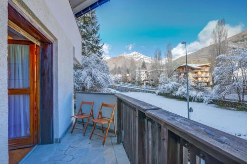 balcone con 2 sedie e montagne innevate di Snow White - Happy Rentals a Bardonecchia
