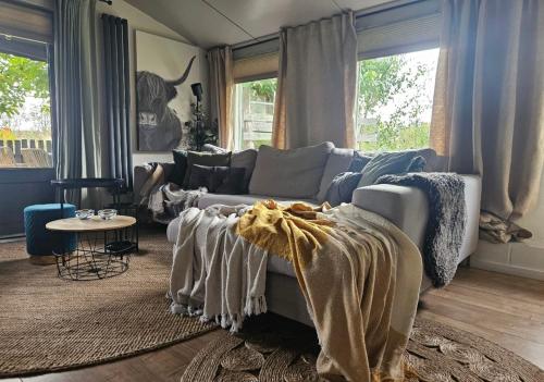 a living room with a couch and a table at Natuurhuisje Hoogeloon PMV in Hoogeloon