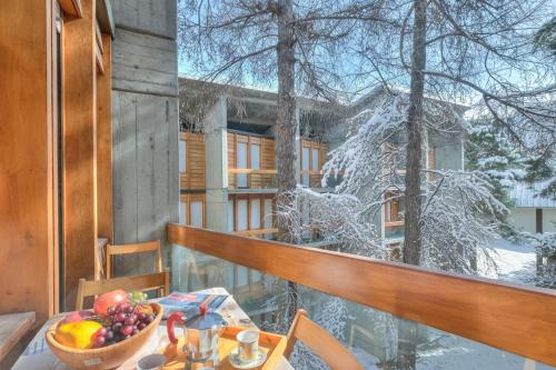 Una mesa con un bol de fruta en un balcón. en Slalom 73 - Happy Rentals, en Bardonecchia