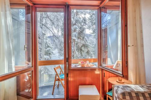 Habitación con ventana y vistas a los árboles nevados. en Slalom 73 - Happy Rentals, en Bardonecchia
