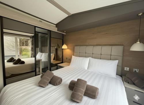 een slaapkamer met een groot wit bed met twee handdoeken bij Luxury Lodge 