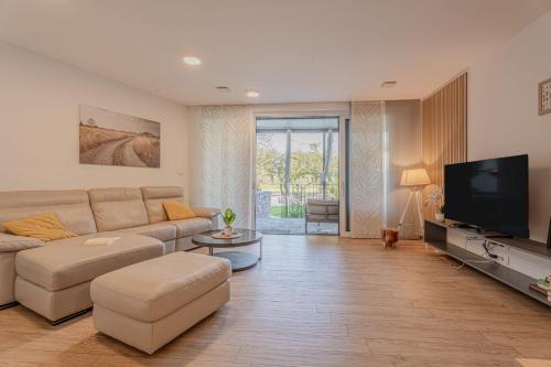 a living room with a couch and a flat screen tv at Vipava River Retreat - Happy Rentals in Vipava