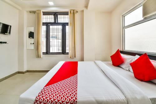 a bedroom with a large bed with red pillows at Hotel O Tirupati Residency Kota Airport in Kota