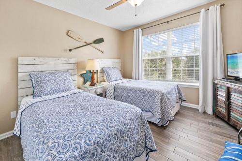 a bedroom with two beds and a tv and a window at Summerlake 29 in Destin