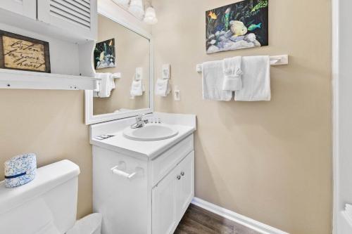 a bathroom with a sink and a toilet and a mirror at Summerlake 29 in Destin