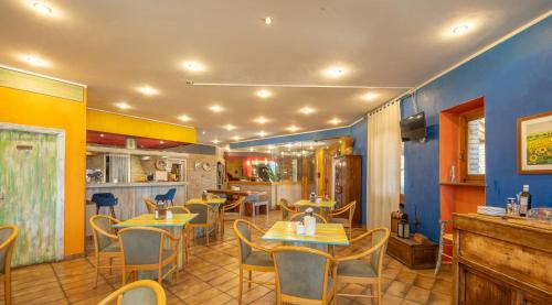 a restaurant with tables and chairs in a room at Hotel Benedetti in Campello sul Clitunno