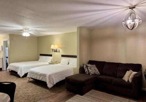 a living room with two beds and a couch at Twin Lakes Inn & RV Park in Stigler