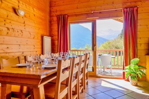 a wooden dining room with a long table with wine glasses at Rochu 10 personnes Spa, Calme & Vue Montagne in Champagny-en-Vanoise