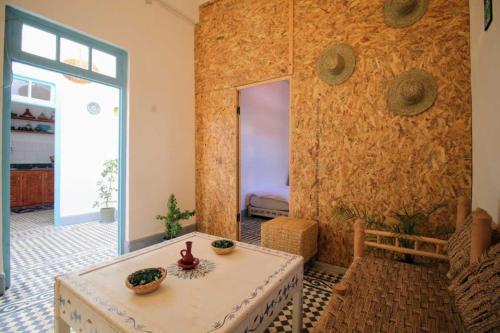 een woonkamer met een tafel en een raam bij Dar janna in Essaouira