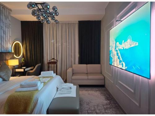 a hotel room with a tv and a bed and a couch at Deluxe Marina View 2BR - Stella Maris Retreat in Dubai