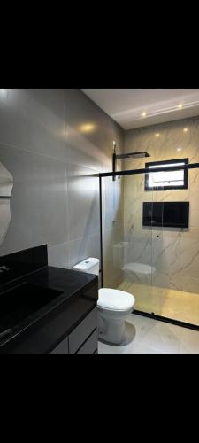 a bathroom with a white toilet and a sink at Apartamento aconchegante e moderno próximo do aeroporto e ao centro in Porto Seguro