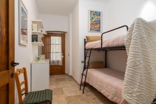 une petite chambre avec deux lits superposés et une cuisine dans l'établissement Casa Ernesto - porzione di colonica, à Monteriggioni