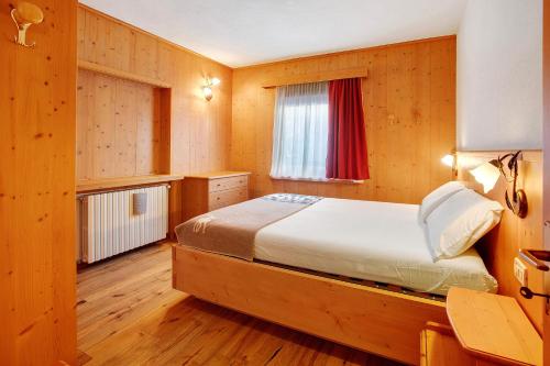 a bedroom with a bed in a wooden room at Tra-monti e Mare Bormio in Valdidentro