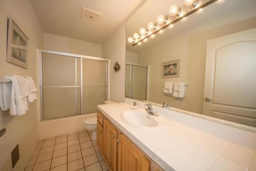 a bathroom with a sink and a toilet and a mirror at 6BR Poipu Kai Oceanfront Retreat Steps to 3 Beaches in Koloa