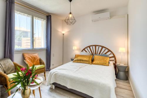 a bedroom with a bed and a chair at La Boite à sel in Aigues-Mortes