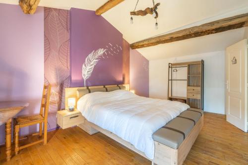 een slaapkamer met een groot bed met een paarse muur bij Maison à Cozes in Cozes