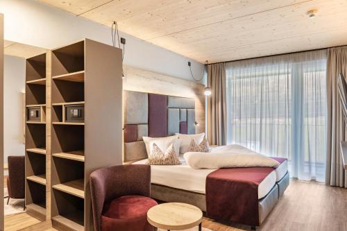 a hotel room with a bed and a chair at Hotel zum Schwanen - Appartement 2 in Pflach