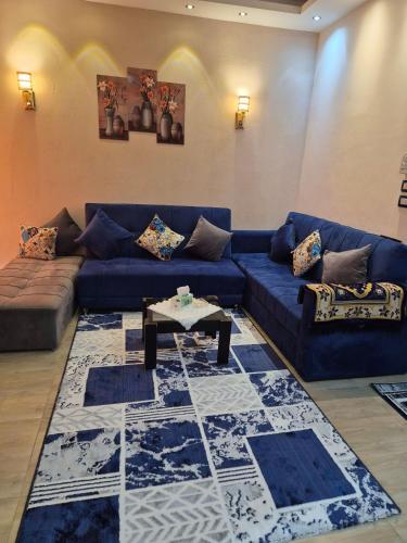 a living room with a blue couch and a table at Star Apartment Hurghada in Hurghada
