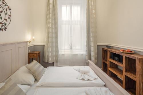 a bedroom with a large white bed and a window at Masná - Old Town Residence in Prague