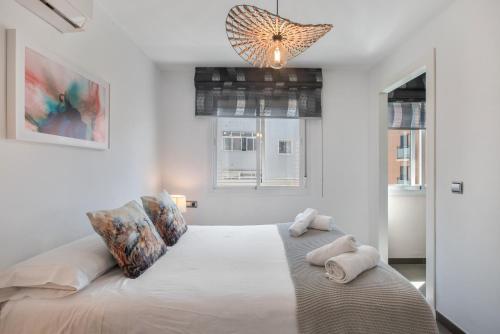 a bedroom with a large white bed with towels on it at Victoria luxury in Málaga